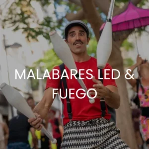 Un hombre feliz hace malabares en un espectáculo callejero con malabares led y fuego escrito encima