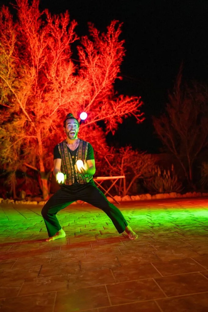 Julián en un espectáculo de malabares con bolas de luz de noche sonriendo